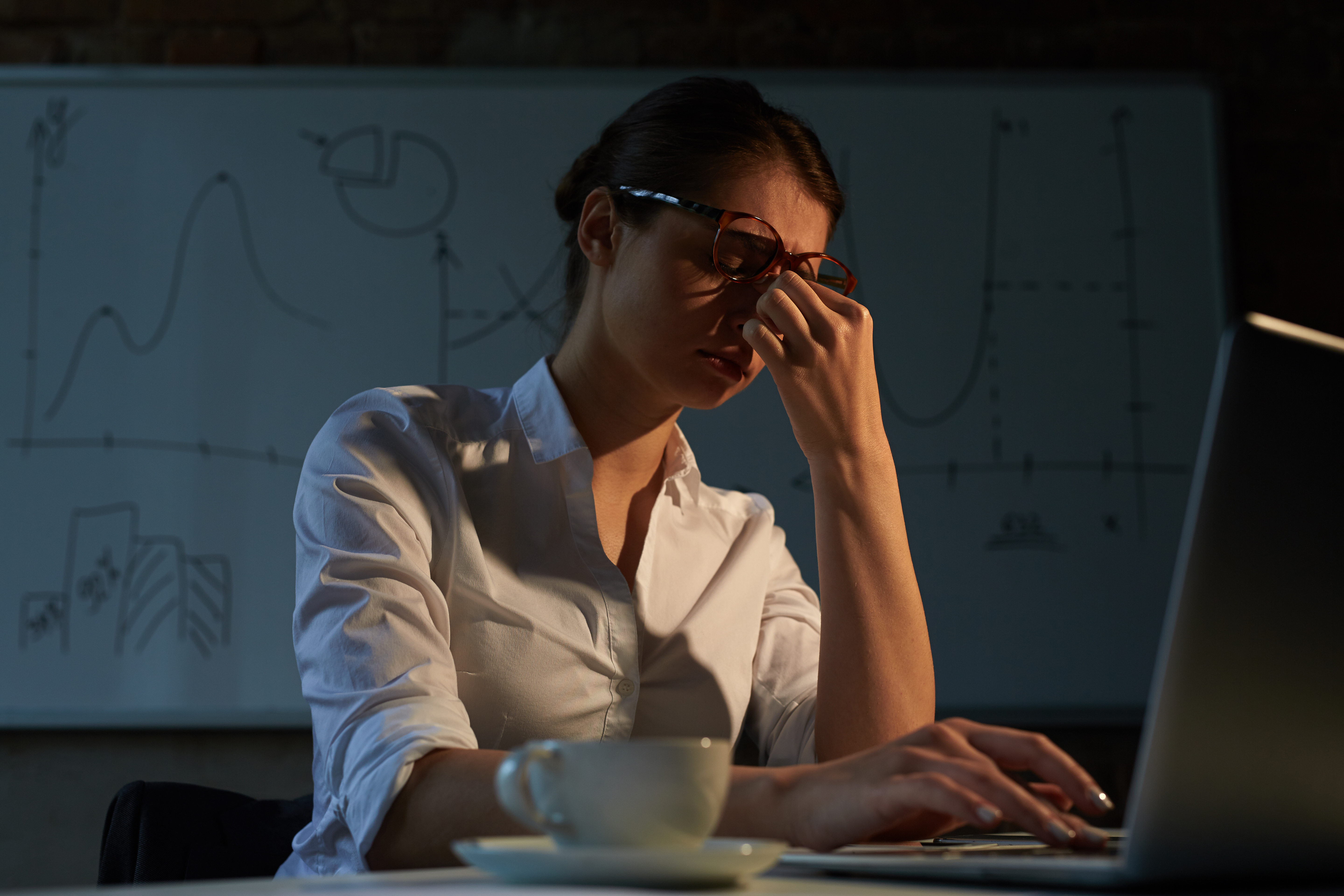 A woman sitting at a desk, frustrated.